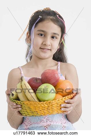 Portrait of a girl holding a basket of fruits View Large Photo Image Stock Image - Portrait of a girl holding a basket of fruits. Fotosearch