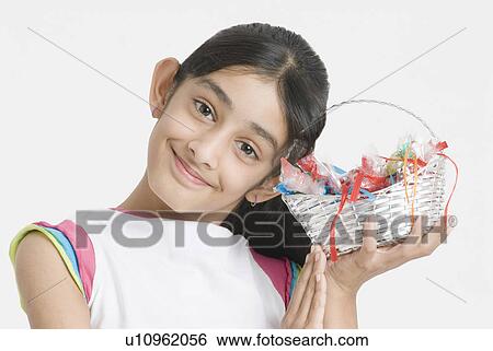 Portrait of a girl holding a basket of candy View Large Photo Image Stock Photograph - Portrait of a girl holding a basket of candy. Fotosearch