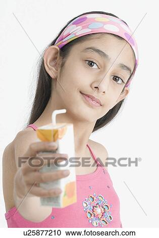 Stock Image - Portrait of a girl holding a carton of juice. Fotosearch