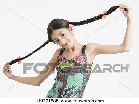 Portrait of a girl holding her braids View Large Photo Image Stock Photo - Portrait of a girl holding her braids. Fotosearch