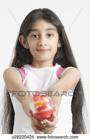 Portrait of a girl holding out an ice cream sundae View Large Photo Image Stock Photography - Portrait of a girl holding out an ice cream sundae. Fotosearch