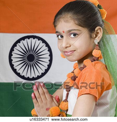 Portrait of a girl in a prayer position in front of an Indian flag View Large Photo Image Stock Image - Portrait of a girl in a prayer position in front of an Indian flag. Fotosearch