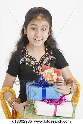 Stock Photography - Portrait of a girl in traditional clothing holding gifts. Fotosearch