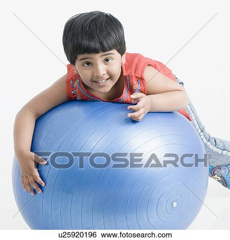 Stock Photograph - Portrait of a girl lying down on a fitness ball. Fotosearch