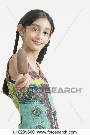 Stock Image - Portrait of a girl offering ice cream. Fotosearch