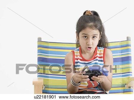 Stock Image - Portrait of a girl playing video game. Fotosearch
