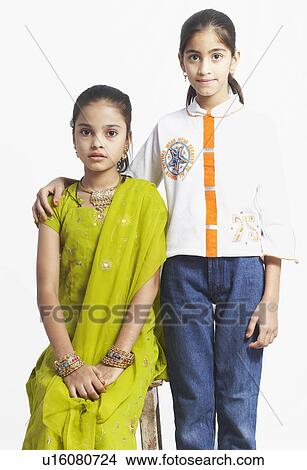Picture - Portrait of a girl sitting with another girl standing beside her . Fotosearch