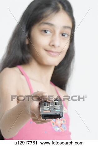 Stock Image - Portrait of a girl using a remote control. Fotosearch