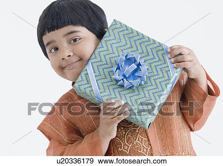 Stock Photo - Portrait of a girl wearing traditional clothes and holding a present. Fotosearch