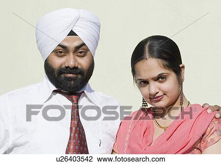 Stock Image - Portrait of a mid adult man with his arm around a young woman. Fotosearch