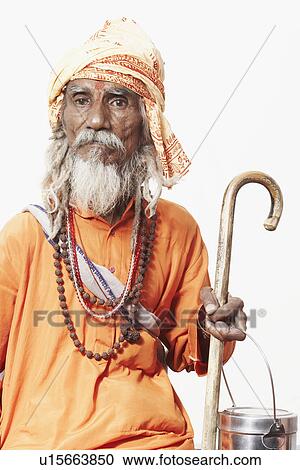 Portrait of a sadhu holding a cane and a utensil View Large Photo Image Stock Image - Portrait of a sadhu holding a cane and a utensil. Fotosearch