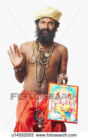 Stock Image - Portrait of a sadhu holding a religious picture. Fotosearch