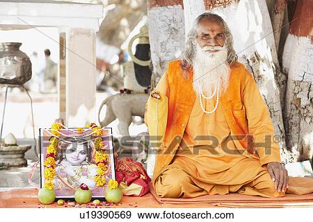 Portrait of a sadhu sitting in front of a tree trunk View Large Photo Image Stock Photo - Portrait of a sadhu sitting in front of a tree trunk. Fotosearch