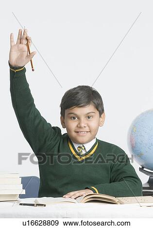 Portrait of a schoolboy smiling with his hand raised View Large Photo Image Stock Photo - Portrait of a schoolboy smiling with his hand raised. Fotosearch