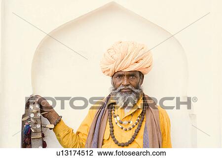 Stock Image - Portrait of a senior man holding a sitar. Fotosearch