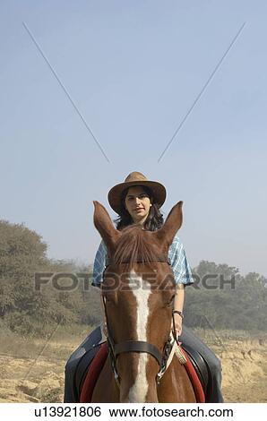 Stock Photograph - Portrait of a teenage girl riding a horse. Fotosearch