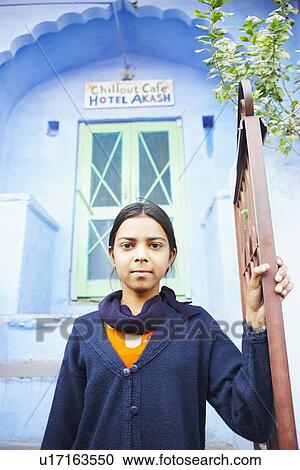 Stock Image - Portrait of a teenage girl standing near a gate. Fotosearch