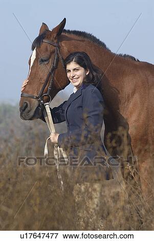Portrait of a teenage girl standing with a horse and smiling View Large Photo Image Stock Photo - Portrait of a teenage girl standing with a horse and smiling. Fotosearch