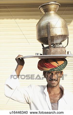 Portrait of a vendor carrying a tea pot on a traditional stove over his head View Large Photo Image Stock Image - Portrait of a vendor carrying a tea pot on a traditional stove over his head. Fotosearch