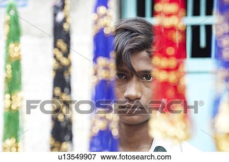 Portrait of a young man behind decorative hangings View Large Photo Image Stock Photo - Portrait of a young man behind decorative hangings. Fotosearch