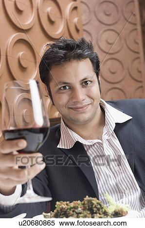 Portrait of a young man holding a glass of red wine View Large Photo Image Stock Photography - Portrait of a young man holding a glass of red wine. Fotosearch