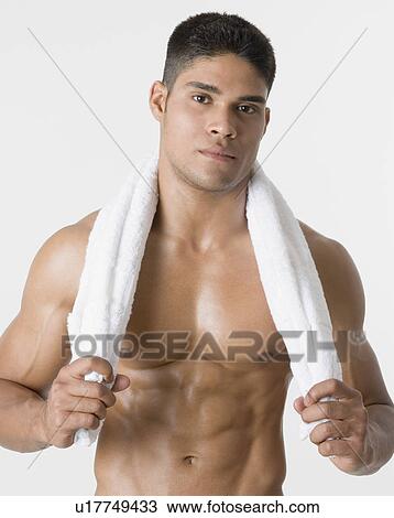 Portrait of a young man holding a towel around his neck View Large Photo Image Stock Image - Portrait of a young man holding a towel around his neck. Fotosearch