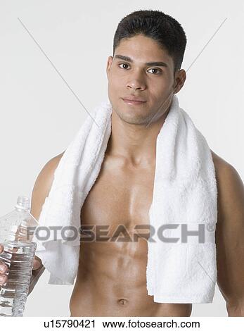 Stock Image - Portrait of a young man holding a water bottle. Fotosearch