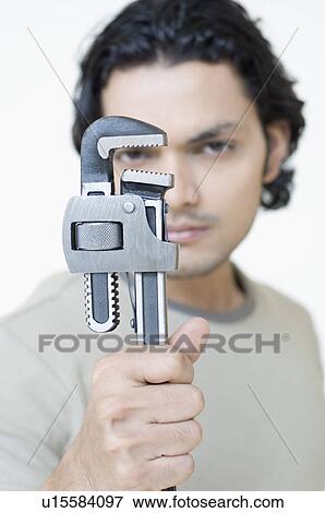 Portrait of a young man holding an adjustable wrench View Large Photo Image Stock Photo - Portrait of a young man holding an adjustable wrench. Fotosearch