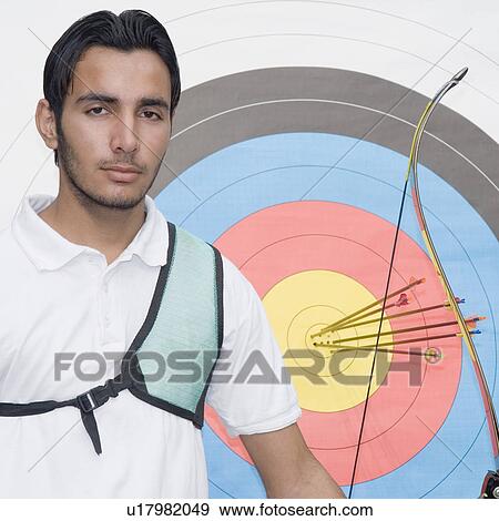 Portrait of a young man standing in front of bull's-eye View Large Photo Image Stock Photo - Portrait of a young man standing in front of bull's-eye. Fotosearch