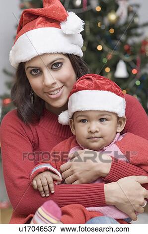 Portrait of a young woman carrying her son View Large Photo Image Stock Photo - Portrait of a young woman carrying her son. Fotosearch