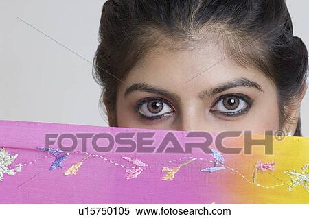 Portrait of a young woman covering her face with a sari View Large Photo Image Stock Photography - Portrait of a young woman covering her face with a sari. Fotosearch