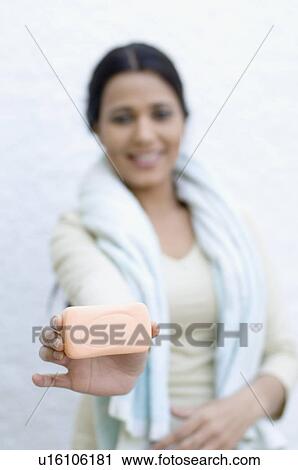 Stock Image - Portrait of a young woman holding a bar of soap. Fotosearch