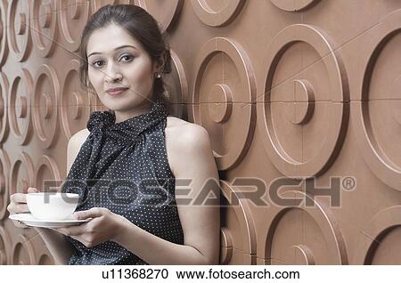 Portrait of a young woman holding a cup of tea View Large Photo Image Stock Image - Portrait of a young woman holding a cup of tea. Fotosearch