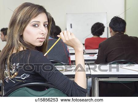 Stock Image - Portrait of a young woman in a classroom. Fotosearch