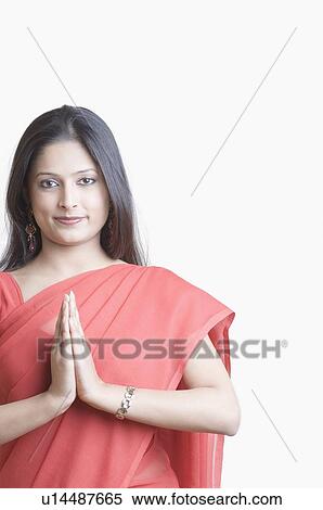 Stock Photography - Portrait of a young woman making a greeting gesture. Fotosearch