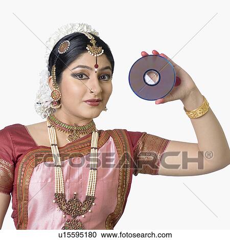 Stock Image - Portrait of a young woman performing Bharatnatyam and holding a CD. Fotosearch