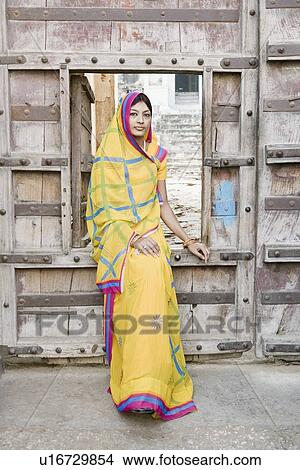 Picture - Portrait of a young woman sitting at a doorway. Fotosearch