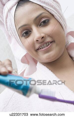 Portrait of a young woman squeezing toothpaste on a toothbrush View Large Photo Image Stock Image - Portrait of a young woman squeezing toothpaste on a toothbrush. Fotosearch