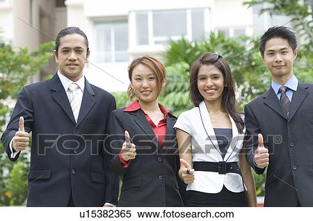 Portrait of two businessmen and two businesswomen showing thumbs up sign View Large Photo Image Stock Photography - Portrait of two businessmen and two businesswomen showing thumbs up sign. Fotosearch