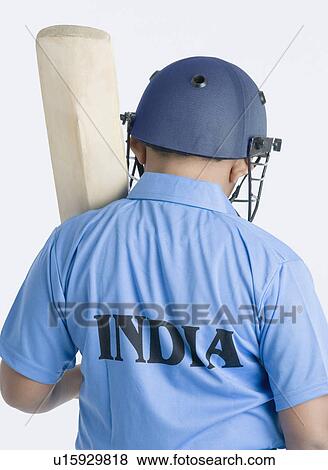 Stock Photo - Rear view of a boy holding a cricket bat. Fotosearch