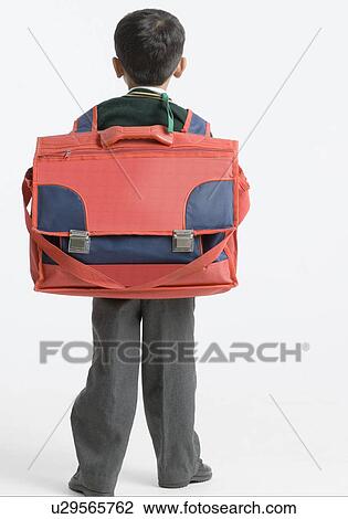 Rear view of a schoolboy carrying a schoolbag View Large Photo Image Stock Image - Rear view of a schoolboy carrying a schoolbag. Fotosearch