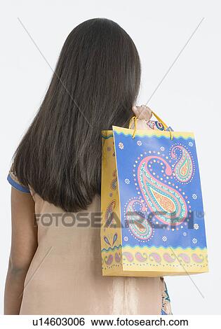 Rear view of a teenage girl carrying a shopping bag View Large Photo Image Stock Photograph - Rear view of a teenage girl carrying a shopping bag. Fotosearch