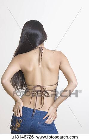 Rear view of a young woman with her hands on her buttocks View Large Photo Image Stock Photograph - Rear view of a young woman with her hands on her buttocks. Fotosearch