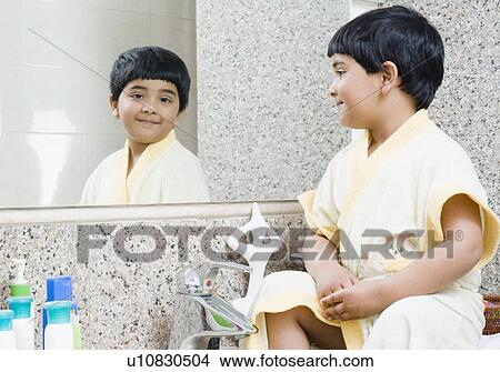 Picture - Reflection of a girl in a bathroom mirror. Fotosearch