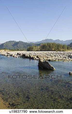 River flowing on rocks with mountains in the background, Jim Corbett National Park, Pauri Garhwal, Uttarakhand, India View Large Photo Image Stock Image - River flowing on rocks with mountains in the background, Jim Corbett National Park, Pauri Garhwal, Uttarakhand, India. Fotosearch