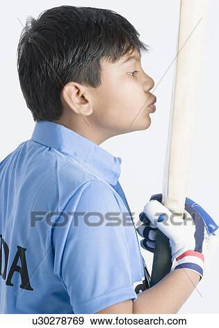 Stock Photo - Side profile of a boy kissing a cricket bat. Fotosearch