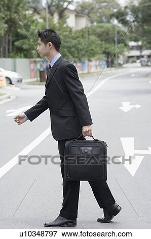 Side profile of a businessman crossing the road View Large Photo Image Stock Photo - Side profile of a businessman crossing the road. Fotosearch
