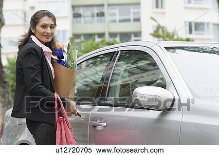 Side profile of a businesswoman opening the door of a car View Large Photo Image Stock Photography - Side profile of a businesswoman opening the door of a car. Fotosearch