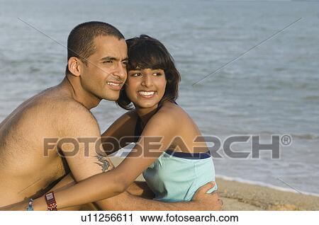 Side profile of a couple hugging on the beach View Large Photo Image Stock Image - Side profile of a couple hugging on the beach. Fotosearch