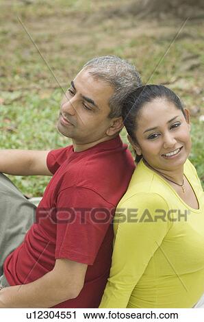 Side profile of a mid adult couple sitting back to back View Large Photo Image Stock Image - Side profile of a mid adult couple sitting back to back. Fotosearch